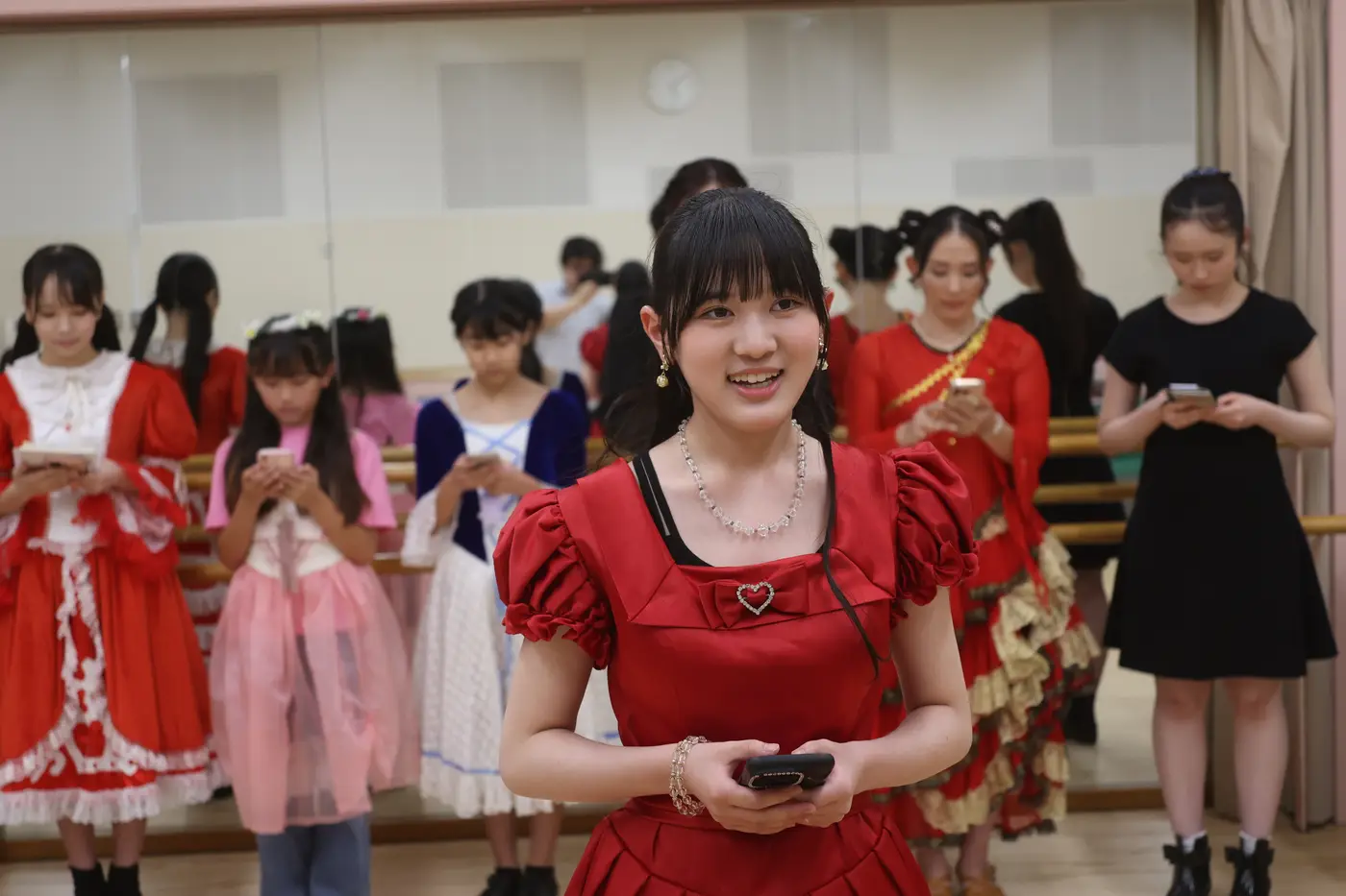 赤いドレスで台本を読む出演者たち