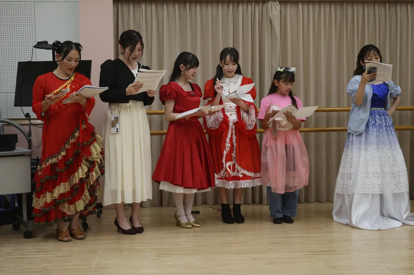 赤い衣裳で読み合わせる出演者たち