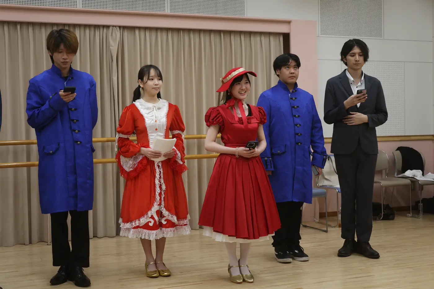赤いドレスと青い衣裳の出演者たち